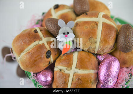 La nourriture dans un panier de Pâques avec les brioches et les oeufs de Pâques en chocolat et mignon lapin decoration Banque D'Images