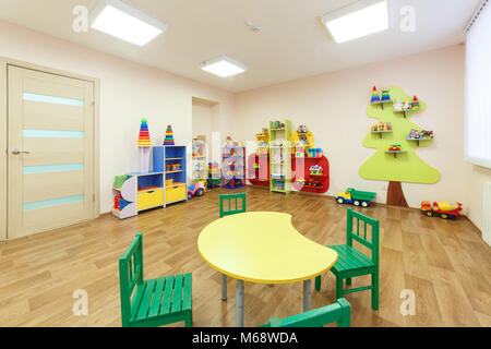Table jaune pour les classes avec des enfants et de la lumière de couleur rose avec salle de jeux dans le jardin d'enfants Banque D'Images