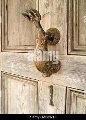 Closeup of old rusty metal fish heurtoir de porte avant en bois en détresse sur Banque D'Images