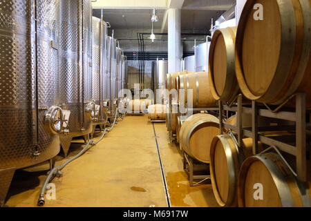 Intérieur d'une cave souterraine moderne avec des réservoirs en aluminium et des tonneaux de vin Banque D'Images