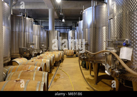 Intérieur d'une cave souterraine moderne avec des réservoirs en aluminium et des tonneaux de vin Banque D'Images