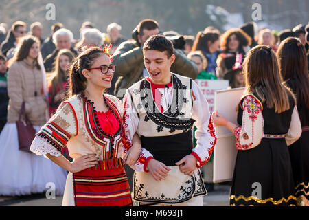 PERNIK, BULGARIE - 26 janvier 2018 : Deux danseurs en costumes folkloriques bulgares, des filles et des garçons et de se préparer à parler de la danse ronde traditionnelle lors de l'assemblée I Banque D'Images