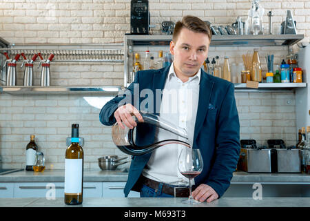 Sommelier vin rouge verser dans un verre à partir de la cuvette de mélange ou carafe. Waiter Banque D'Images