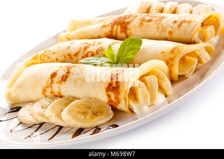 Crêpes aux bananes et crème sur fond blanc Banque D'Images