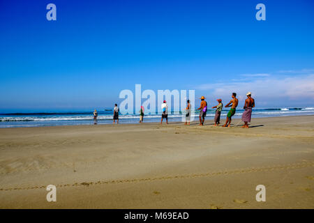 Un groupe de pêcheurs est de tirer un filet de pêche de la mer, sur la plage Banque D'Images