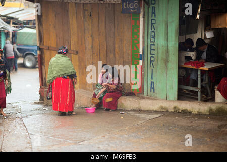 Autochtones, ethniques un Maya Ixil femme cesse d'acheter des biens à partir de deux filles au marché. San Gaspar Chajul, triangle Ixil, au Guatemala. Banque D'Images