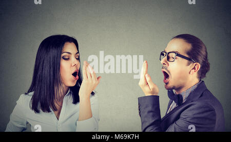 Jeune couple femme et homme contrôler leur souffle avec hand gesture Banque D'Images