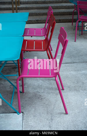 Rose et rouge avec des chaises d'extérieur tables bleu Banque D'Images