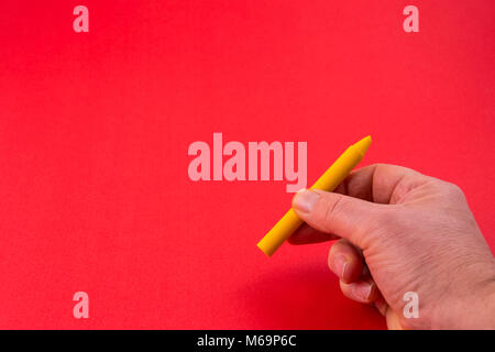 Un crayon de cire jaune sur la main Banque D'Images