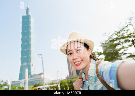 Jeune femme tenant un backpacker asiatique avec Taipei selfies plus haut édifice. Elle est satisfaite de la ville de Taipei. Banque D'Images