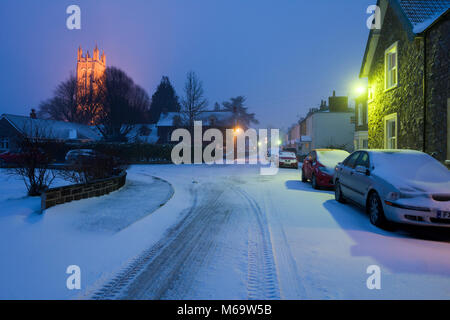 Un village rural street couverte de neige pendant la nuit, Wrington, North Somerset, Angleterre. Banque D'Images