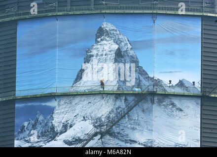 02 mars 2018, l'Allemagne, l'Oberhausen : un grimpeur industrielle met en place d'un 1400 m² grand poster pour l'exposition "der Berg ruft" (lit. Les appels de montagne) à l'gazomètre d'Oberhausen. L'exposition a lieu du 16 mars au 31 décembre 2018 et affiche une sculpture monumentale du Cervin à l'espace aérien de 100 mètres de haut du gazomètre. Photo : Roland Weihrauch/dpa Banque D'Images