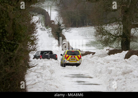 Uttoxeter, Staffordshire, Royaume-Uni. 09Th Mar, 2018. Météo France : un 4x4 voiture de police tente de parvenir à un brin 4x4 coincé dans d'énormes amoncellements de neige près d'Uttoxeter, en raison de la neige à partir de la tempête Emma et la "bête de l'Est'. Uttoxeter, Staffordshire, Royaume-Uni. 2 mars 2018. Crédit : Richard Holmes/Alamy Live News Banque D'Images