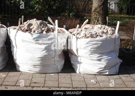 Sacs Poubelles blancs avec des moellons d'un chantier de construction Banque D'Images