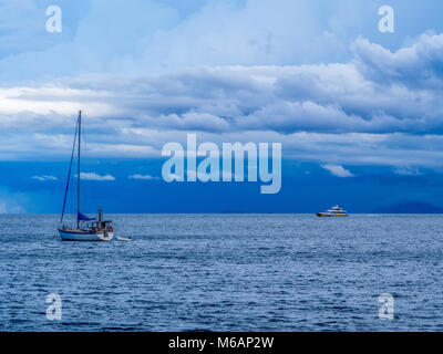 Magnetic island ferry en route à Nelly Bay sur un jour de tempête. Bateau à voile ancré dans l'avant-plan. Banque D'Images