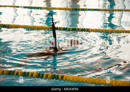 Le sergent de l'armée américaine. Jacobus Bois, affecté à la Police militaire de Bruxelles à la U.S. Army Garrison Benelux, nage tout en gardant la plupart de ses armes hors de l'eau au cours de la garnison's Best Warrior la concurrence dans la piscine du Grand Quartier général des Puissances alliées en Europe, Belgique, le 21 février 2018. (U.S. Army Banque D'Images