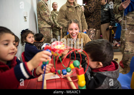 Airman Senior Maria Lopez, affecté à la 332d de l'Escadron des Forces de sécurité de la Force expéditionnaire du Canada, joue avec des enfants lors d'un drop-off de don le 26 février 2018, dans un endroit inconnu. Les membres réunis de service et de fournitures livrées dans leur temps libre en vue d'exploitation inhérents à résoudre objectifs. (U.S. Air Force Banque D'Images