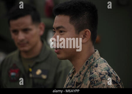 Corps des Marines des États-Unis Le Cpl. Aphiwat Promkhan, une aile Marine 172 de l'Escadron de soutien de l'aérodrome de expéditionnaire de Sacramento en Californie, Marine se traduit pour les Marines de son escadron et les pompiers de la Marine royale thaïlandaise, Février 20, 2018, avant un live burn pour simuler l'écrasement d'un aéronef à l'Aéroport International d'U-Tapao, la province de Rayong, Thaïlande. "C'est formidable d'être un traducteur. Il a été vraiment intéressant : J'ai trouvé plus facile de traduire à l'Anglais, Thaï, mais dans l'autre sens a été beaucoup plus difficile. L'expérience acquise au cours de l'exercice Gold Cobra a été extraordinaire ; j'ai pu rencontrer beaucoup de gens. La meilleure partie de cela a été Banque D'Images