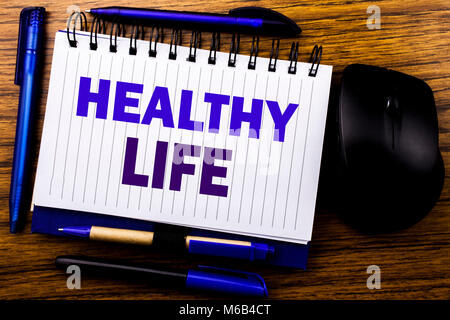 Texte manuscrit montrant la vie en bonne santé. Concept d'affaires pour la bonne santé de l'alimentation sur les ordinateurs portables note écrite livre papier sur fond de bois. Lette mot bleu Banque D'Images