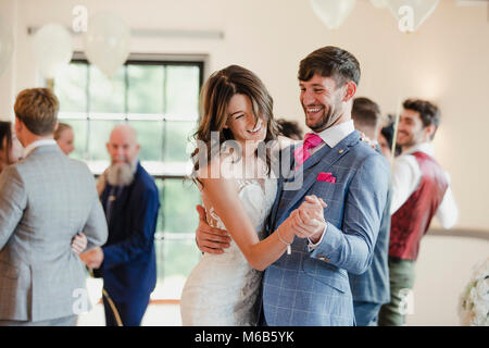 Couple de jeunes mariés dansent ensemble le jour de leur mariage avec tous leurs invités. Banque D'Images