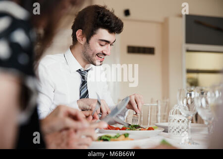 Gros plan des invités du mariage de parler tout en appréciant le démarreur de leur repas à un mariage. Banque D'Images