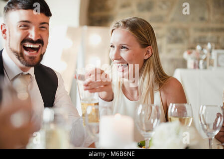 Les invités s'amusent tout en restant assis à la table pour le repas. Ils sont parler et rire tout en buvant du vin et bière. Banque D'Images