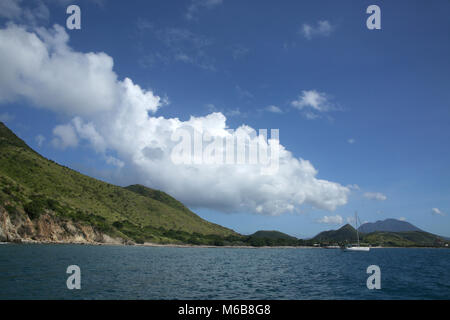 Vue sur la côte de la mer avec un bateau à voile, St Kitts, Caraïbes. Banque D'Images