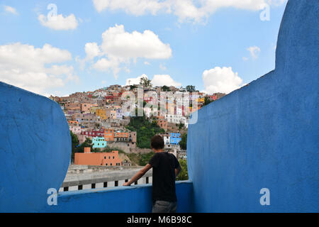 Jeune homme à la recherche sur le paysage coloré de Guanajuato, au Mexique, d'une forme bizarre, peinte en bleu balcon. Banque D'Images