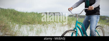 Image composite de digital composite of handsome man on a bike ride Banque D'Images