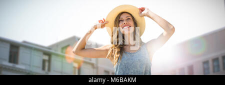 Image composite de portrait d'une femme de toucher son chapeau de paille Banque D'Images