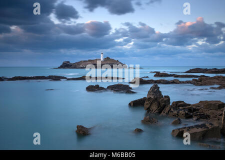 Coucher de soleil sur le phare de Godrevy Godrevy sur l'île dans la baie de St Ives avec la plage et les rochers en premier plan, Cornwall Banque D'Images