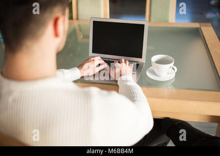 Retour portrait de l'homme assis à table de travail à la maison Banque D'Images