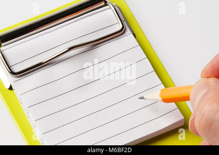 Un homme écrit à la main sur le bloc-notes avec crayon blanc contre un fond blanc Banque D'Images