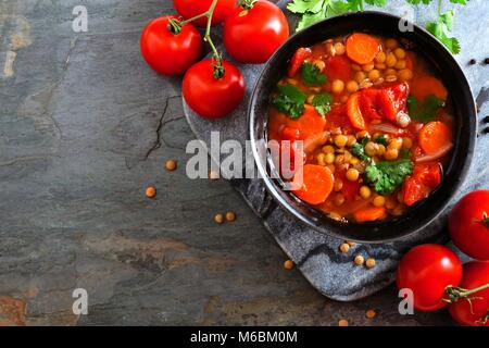 La tomate fait maison, la soupe aux lentilles, au-dessus de la frontière avec l'angle de l'espace de copie sur un arrière-plan en ardoise foncé Banque D'Images