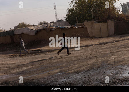 Mossoul, Irak. 8 décembre 2016 - 2 garçons Run for Cover dans les rues de Mossoul au cours d'une campagne visant à débarrasser la coalition de Mossoul Daesh. - Â© Ty Faruki Banque D'Images