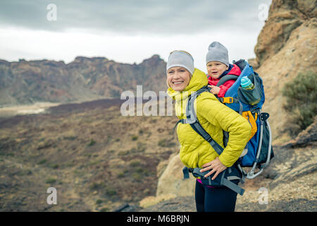 Heureuse fête avec petit garçon voyager en sac à dos. Randonnées aventure avec enfant sur l'automne voyage en famille dans les montagnes. Voyage Vacances d'auto pour bébé avec Banque D'Images