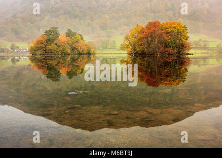 Les couleurs de l'automne de l'île Heron et peu isle se reflètent dans les eaux calmes de Rydal l'eau dans le Lake District. Banque D'Images