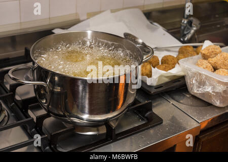 Chef de friture dans flaming pan sur une cuisinière à gaz dans la cuisine commerciale. Banque D'Images