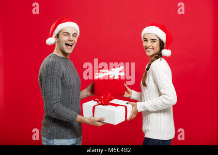 Concept de Noël - jeune beau couple de donner des cadeaux à l'autre célèbre dans le jour de Noël Banque D'Images