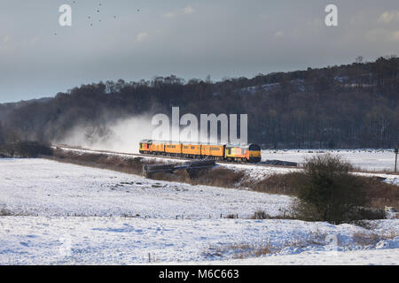 2 Colas Rail Freight Transport locomotives classe 67 un réseau de surveillance de l'infrastructure ferroviaire train dans la neige sur la ligne de côte de Cumbrie Banque D'Images