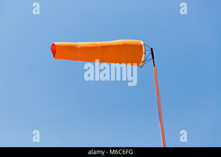 Manche à vent orange contre le ciel bleu Banque D'Images