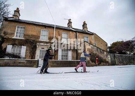 Deux croix homme ski de comté à travers le village de Batheaston près de Bath dans le Somerset après de fortes chutes de neige. Bête de l'Est, tempête Emma. Banque D'Images
