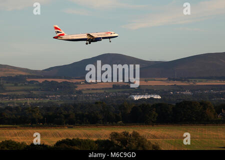Avec le soleil qui éclaire le paysage et les collines de Pentland derrière un british airways jet effectue son approche finale sur l'aéroport d'Édimbourg Banque D'Images