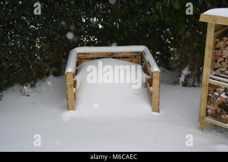 Compost constitué de palettes et d'une partie du magasin avec un journal dans le jardin fabriqués à partir de bois traités et couverts de neige importante après tempête Banque D'Images