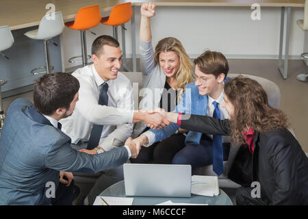 Cheerful business team shaking hands et happy businesswoman with hands up célébrant la réussite sur le marché de nouveaux Banque D'Images