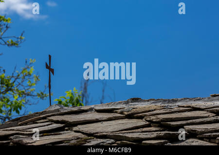Vintage croix métallique sur toiture tuiles en pierre Banque D'Images