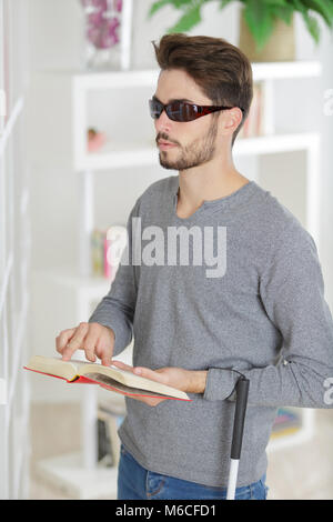 Homme aveugle de lire un livre en braille à la maison Banque D'Images