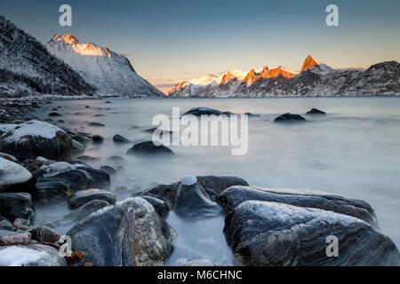 Fjord norvégien, les montagnes neige-couvertes au coucher du soleil, près de l'île de Senja, Mefjordvaer, Norvège Banque D'Images