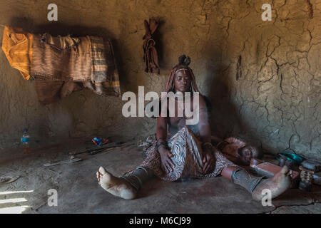 De la femme Himba ou Ovahimba personnes Nettoyage et désinfection des vêtements et du corps, district de Kunene, Namibie Banque D'Images