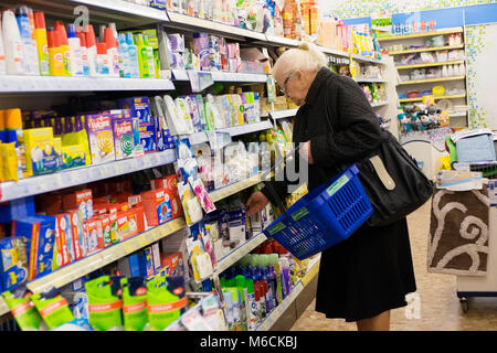 Une vieille dame shopping dans une pharmacie pharmacie Banque D'Images